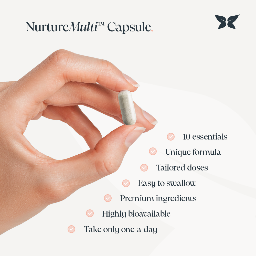 A hand holding a white capsule labeled "NurtureMulti™ Capsule" with text describing product benefits: 10 essentials, unique formula, tailored doses, easy to swallow, premium ingredients, highly bioavailable, and take only one-a-day. A butterfly logo is visible in the top right.