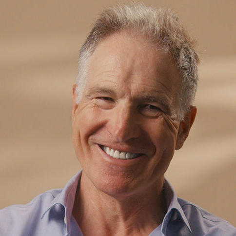 Close-up of Professor Mark Johnson smiling against a warm background. 