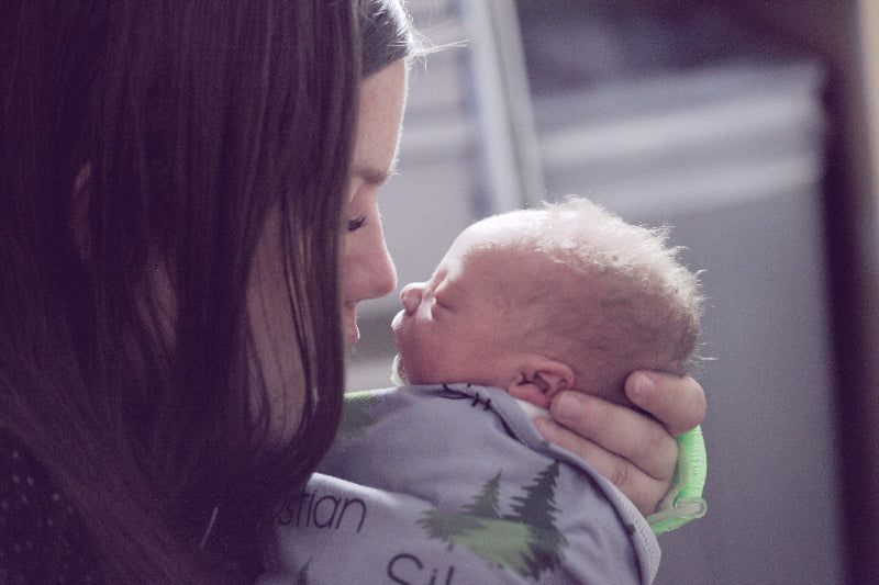 Lady holding a newborn baby nose to nose in a loving embrace 