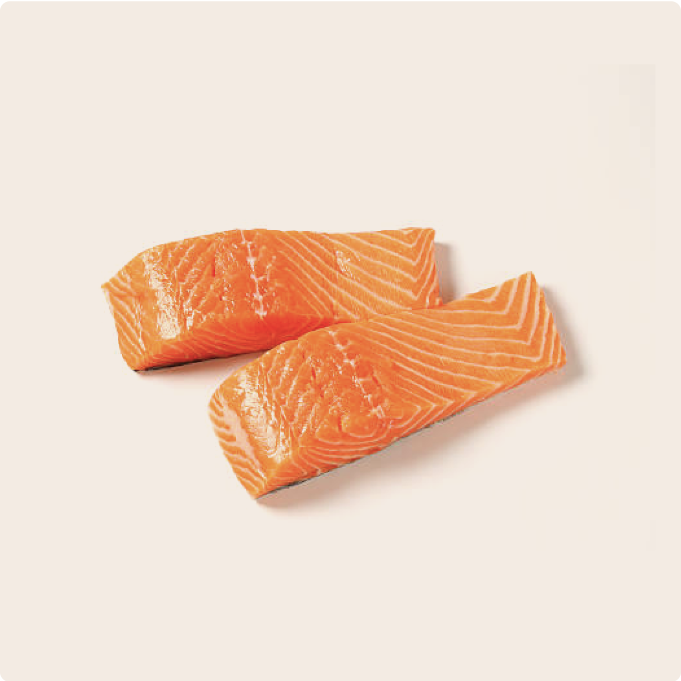 Two cuts of raw salmon, on a plain cream background, high in copper 