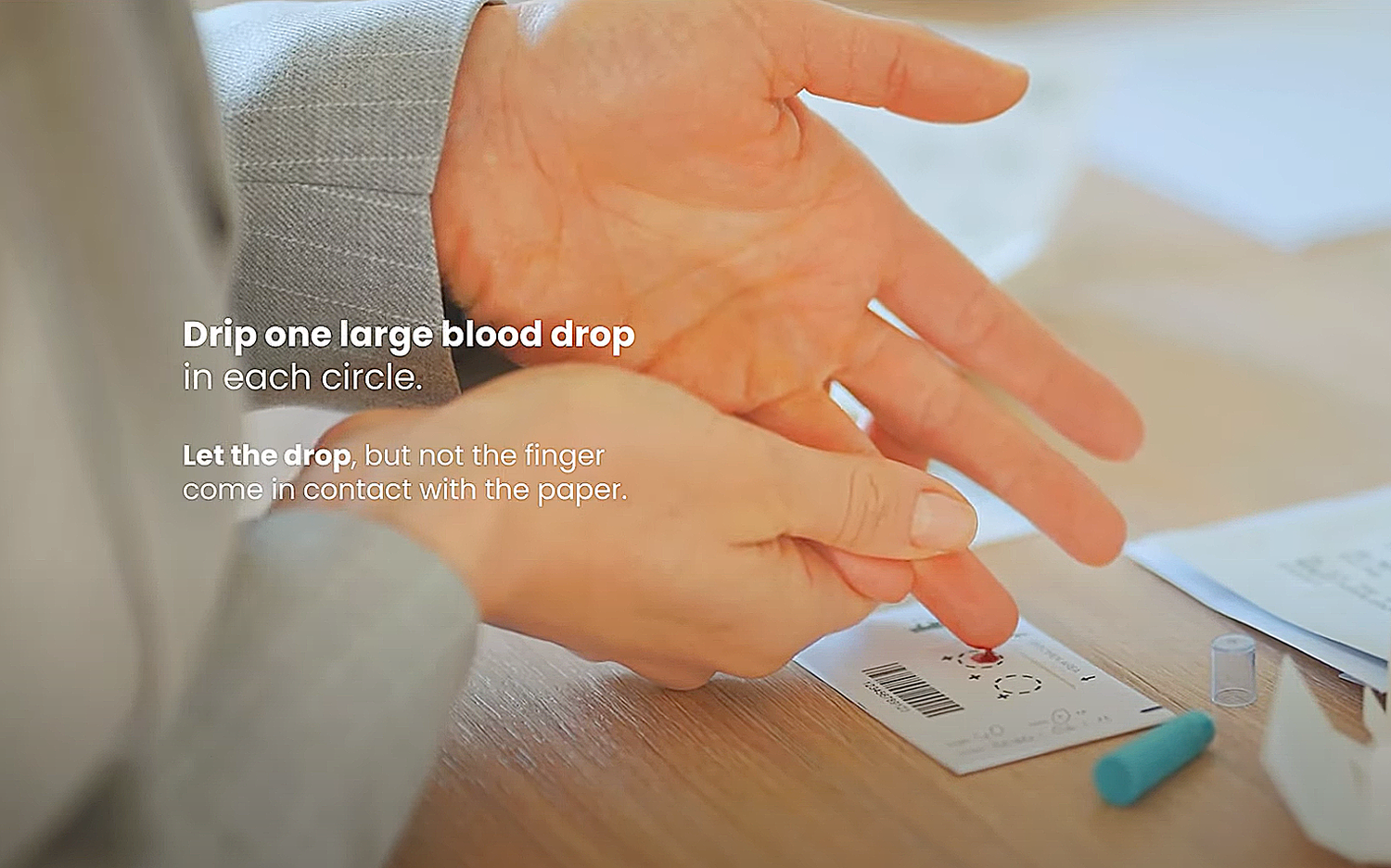 Hands squeezing a blood droplet onto a sample card, with text instructions overlaid