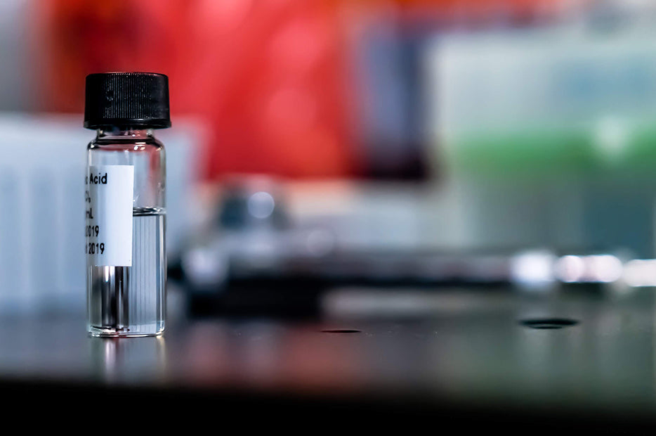 Small glass bottle with a label on a laboratory counter.