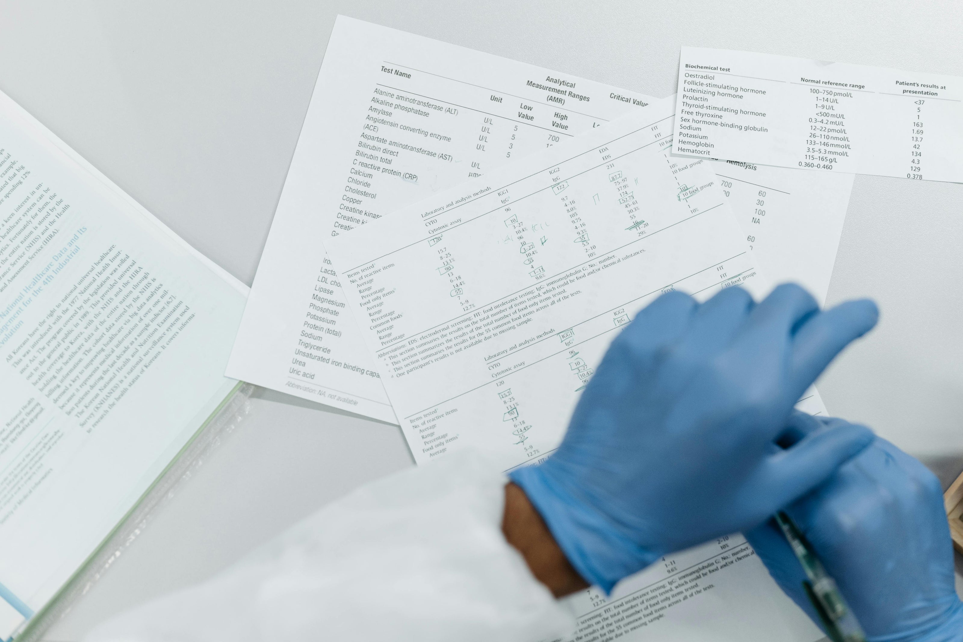 Medical professional wearing gloves reviewing research papers 
